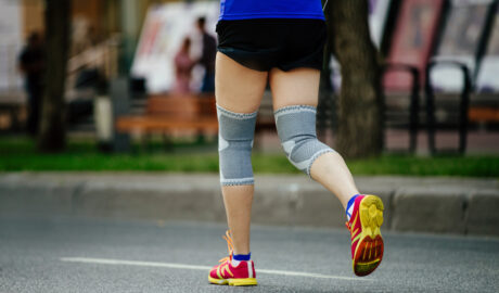 Woman,Runner,With,Knee,Pads,On,His,Knees,Running,Street