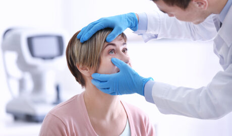 Ophthalmologist examining eyes of mature woman in clinic